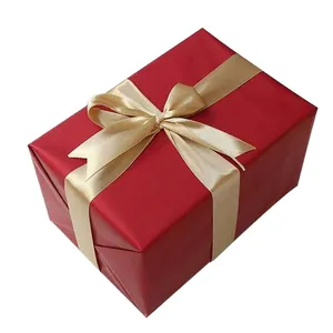 Boîte cadeau rouge festive avec un élégant nœud en satin doré pour Noël et le Nouvel An