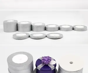 Close-up detail of various sizes of silver glitter ribbon rolls for gift and cake packaging
