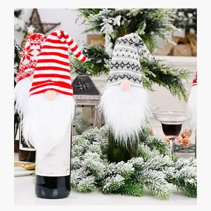 Detail view of festive gnome wine bottle covers with knitted hats and white beards.