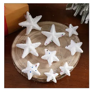 Estrellas de Navidad de espuma blanca con lentejuelas sobre una rodaja de madera