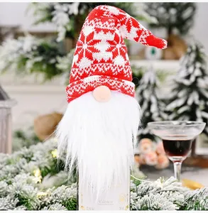 Detailed view of a Christmas gnome wine bottle cover with a red knitted snowflake hat.