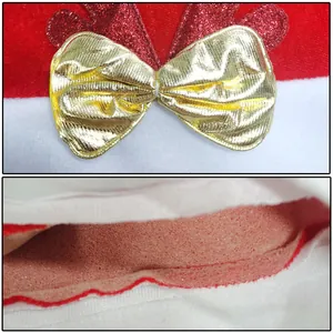 Detailed macro view showing gold metallic bow and foam core layer on red velvet Christmas hat