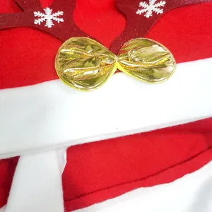 Close-up macro detail of a red Christmas hat with reindeer antlers and a golden bow