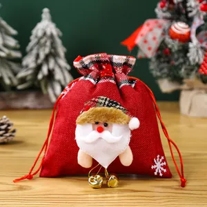 Feestelijke kerstcadeauzak van jute met kerstmanfiguur en gouden kleine belletjes
