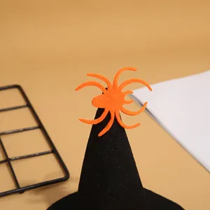 Detalle de una araña de fieltro naranja en un sombrero de bruja negro para mascotas de Halloween.