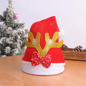 Detail of Christmas hat with golden reindeer antlers and red polka dot bow decoration.