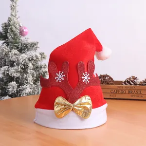 Close-up of a red plush Santa hat featuring glittery antlers and a metallic gold bow