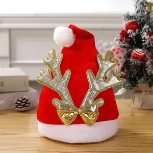 Velvet Christmas hat with gold glittery reindeer antlers and bow on a wooden table