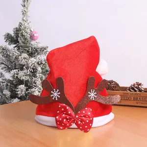 Detail of red Christmas hat with plush antlers and a polka dot bow tie decoration