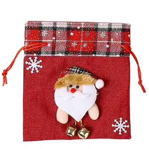 Rode jute kerstcadeauzak met kerstman-applicatie en gouden bellen versiering.