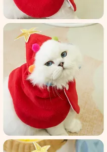 Detailed view of red festive cat Christmas cape featuring a gold star and pom-poms