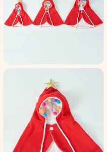 Close-up detail of a red Christmas pet cape with a gold star and colorful pom-poms.