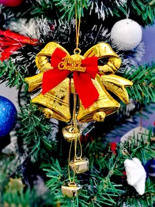 Detailansicht eines goldenen Weihnachtsglocken-Anhängers mit roter Schleife an einem Baum