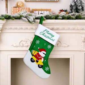 Vista detallada del calcetín de Navidad verde con Papá Noel en un scooter amarillo