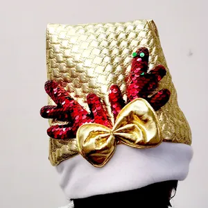 Close-up detail of a golden Christmas hat with red sequin antlers and a bow decoration.