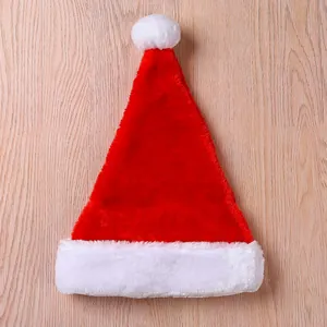 Detailed view of a classic red and white plush Santa hat on a wooden surface