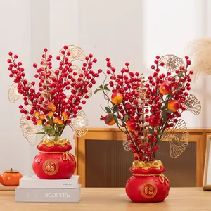 Festliches chinesisches Neujahrs-Blumenarrangement mit roten Beeren und Goldblättern