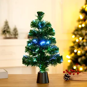 Close-up of mini fiber optic Christmas tree with colorful glowing lights on a wooden table