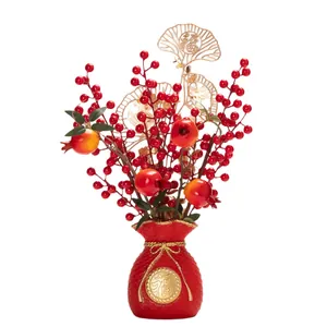 Traditionelle chinesische Neujahrsdekoration mit roten Beeren und goldenen Blättern in Vase