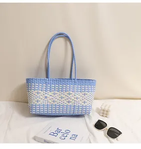 Dettaglio della borsa a cesta intrecciata in plastica blu e bianca per la spiaggia