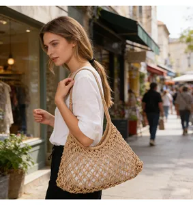 Borsa a tracolla boho in macramè beige fatta a mano portata da una modella in strada