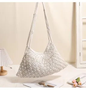 Primo piano di una borsa in rete macramè bianca fatta a mano con trama traforata complessa