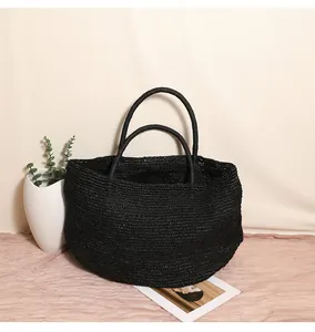 Detailaufnahme der großen, handgewebten Bast-Strohtasche in Schwarz für den Strand
