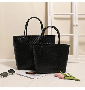 Macro view of black woven plastic tote bags showcasing elegant texture and design