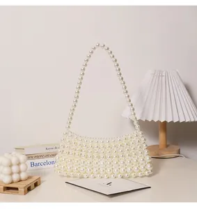 Elegante weiße Handtasche aus Perlen präsentiert mit ästhetischen Lifestyle-Requisiten