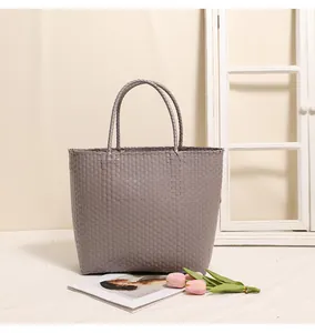 Elegant gray woven plastic tote bag for shopping and beach vacations in a lifestyle setting