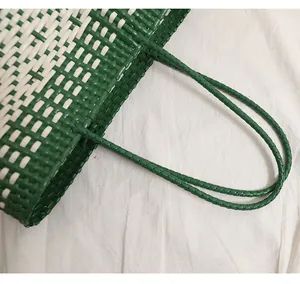 Dettaglio ravvicinato dei manici intrecciati e della trama verde di una borsa da mare