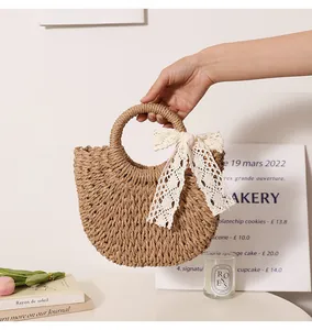 Detail shot of a handmade straw woven bag with a delicate lace bow on circular handle