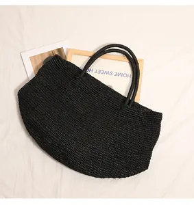 Detail einer schwarz dicht gewebten Bast-Tasche mit stabilen Griffen auf weißem Grund