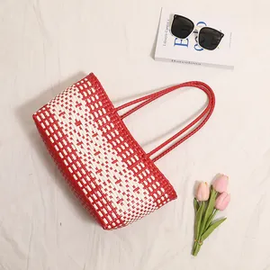 Elegante borsa mare in plastica intrecciata bianca e rossa in un set di lifestyle