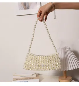 Detailansicht einer handgefertigten Perlen-Achseltasche, die in einem Raum gehalten wird.