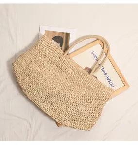 Große Bast-Strohtasche für den Strandurlaub auf einem weißen Stoffhintergrund gezeigt