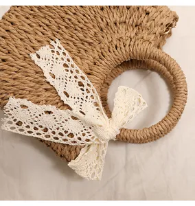 Close-up of hand-woven straw bag texture with elegant white lace bow detail