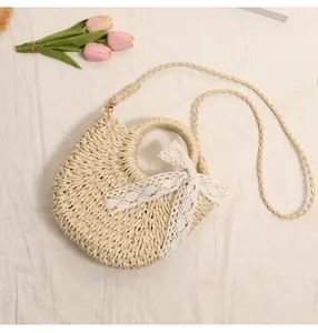 Semi-circular straw woven bag with white lace bow and pink tulips on white fabric