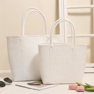 Two white woven plastic tote bags in small and large sizes for beach vacation and shopping