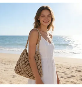 Model carrying a handmade beige macramé woven shoulder bag on a sunny tropical beach