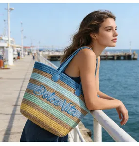 Vista dettagliata di una grande borsa da spiaggia in corda ricamata e colorata al mare