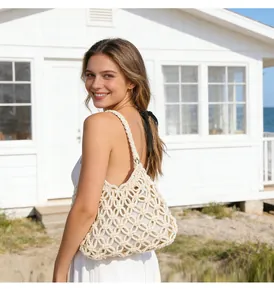 Model wearing a white hollow-out crochet cotton thread shoulder bag for beach vacation.