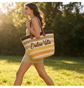 Grande borsa da spiaggia tessuta colorata con ricamo Dolce Vita in un parco al sole.