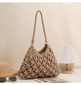 Detailed view of handmade macrame hollow-out shoulder bag on a vacation-themed set.