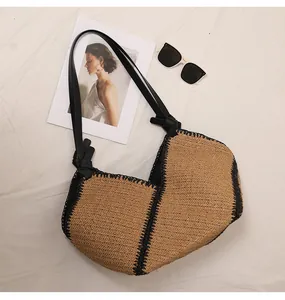 Detail of large straw tote bag with black trim and woven texture for beach vacation.