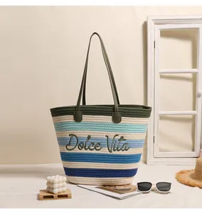 Dettaglio di borsa da spiaggia a righe con ricamo Dolce Vita in ambiente lifestyle