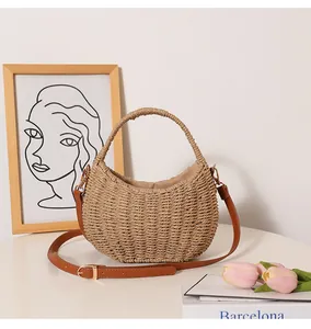 Detailed view of a handmade woven straw beach bag with leather strap and round handle