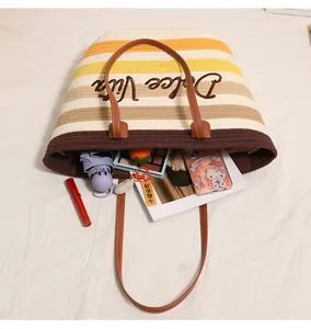 Vista dettagliata di una borsa da spiaggia tessuta a righe con grande capacità.