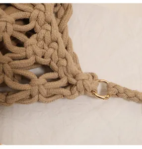 Macro view of handmade hollow cotton woven beach bag featuring a gold metal ring connector.