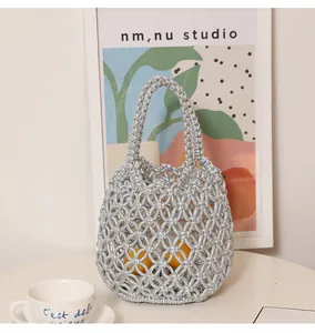 Borsa a secchiello intrecciata argento con rete traforata per le vacanze.